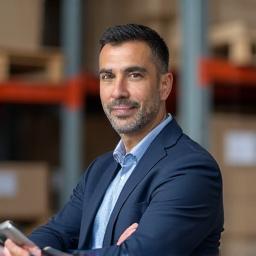Retrato profesional de Carlos Restrepo, jefe de logística de Aurora Floralia, organizando entregas.